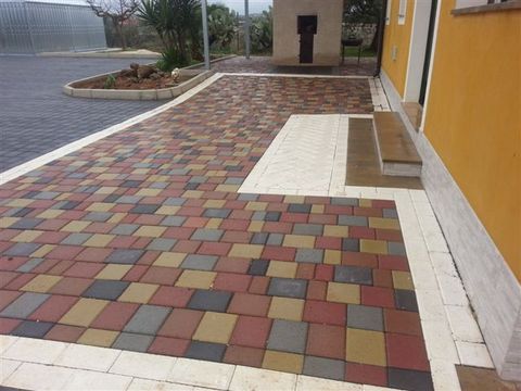 Realizzazione privata di un tappeto di masselli VOLTERRA in mix di colori delimitato da due file di mattonelle PALIO bianco.