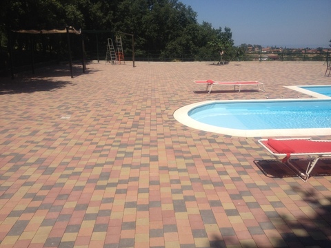 Belpasso (CT) villa privata. Piastrelle in cemento per pavimenti esterni. Palatino Linea Hi Class in mix di colore per la realizzazione di pavimenti a bordo piscina, una mattonella dalle caratteristiche DRENANTI, ANTISCIVOLO E ANTISLITTAMENTO. La superficie liscia e compatta li rende piacevoli al tatto e sicure per sfrezzanti corse a pidi nudi.