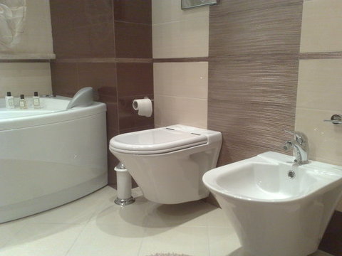bagno realizzato con nirvana avorio e wenge ,particolare con fascia scultura rame. vasca da bagno novellini , sanitari sanindusa jade sospesi.