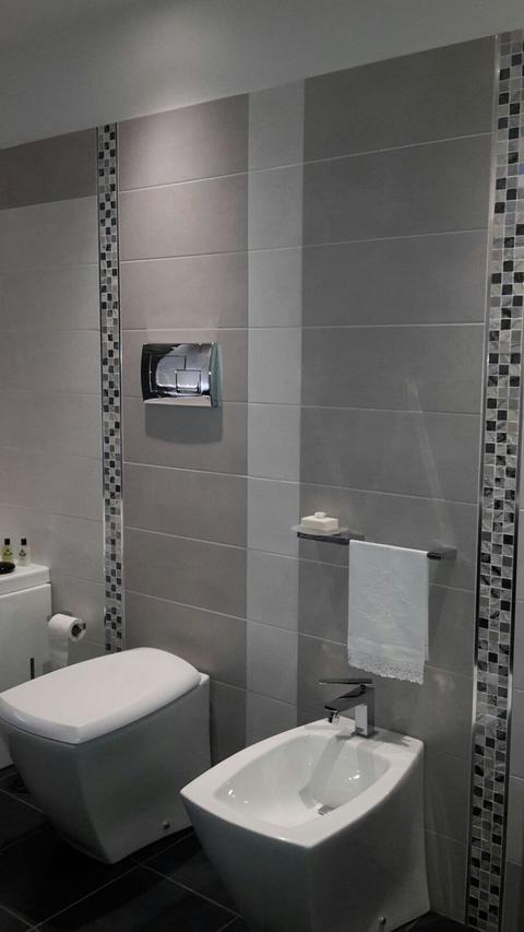 Dettaglio bagno con strisce di mosaico.