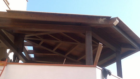 Copertura veranda a forma di ragnatela, prodotto con travi lamellari e perline di Abete impregnate e verniciate, tetto coibentato e ventilato con copertura di tegola canadese.