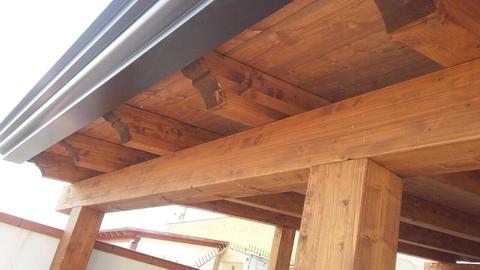 Tettoia in legno con travi lamellari completa di tegole in coppo, grondaia e perline