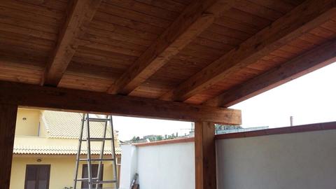 Tettoia in legno con travi lamellari completa di tegole in coppo, grondaia e perline