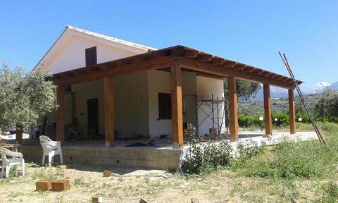 Veranda addossata una falda in legno lamellare costruita ad angolo.