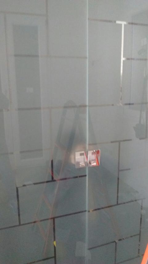 Porta in vetro temperato 8mm trasparente decori rettangolari, disposti in varie angolazioni, lavorati in sabbiatura, lasciando uno spazio fra le figure geomentriche di 1cm in trasparenza. In seguito è stato applicato su tutta la superficie un prodotto acidante per rendere satinata la parte in sabbiatura. Maniglie e accessori in acciaio.