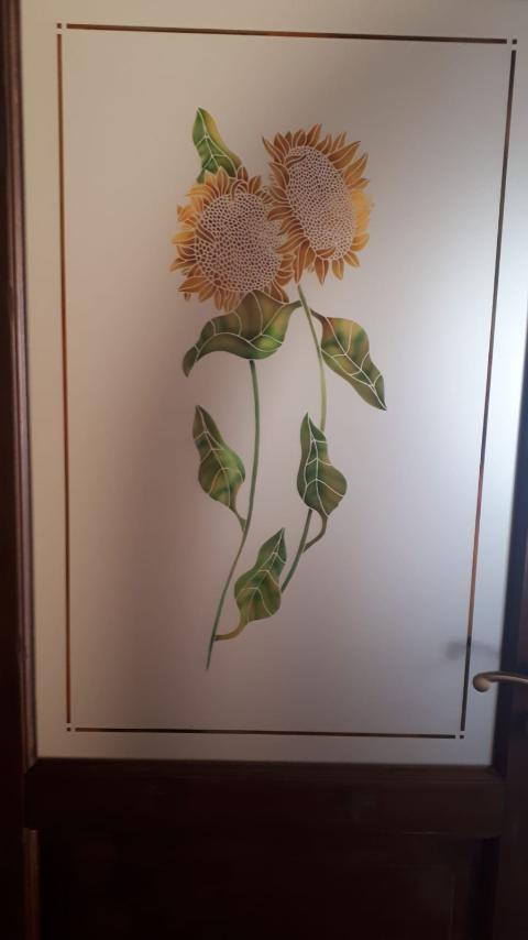 Vetro 5mm satinato con raffigurazione di girasoli nella parte centrale e una cornice interna lungo la zona perimetrale.