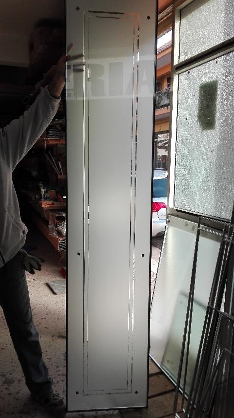 Vetro trasparente 5mm su cui è stata effettuata una lavorazione di sabbiatura lasciando una doppia cornice interna in trasparenza.