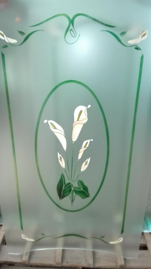 Vetro satinato su cui è stata effettuata una lavorazione di scavatura e colorazione sui vari elementi decorativi.