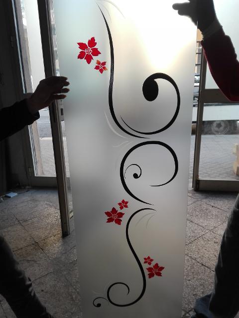 Vetro satinato 5mm decorato in stile moderno scavato e colorato in nero, mentre i fiori arricchiti dal rosso sfumato con il giallo, lasciando qualche particolare in sabbiatura.