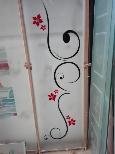 Vetro satinato 5mm decorato in stile moderno scavato e colorato in nero, mentre i fiori arricchiti dal rosso sfumato con il giallo, lasciando qualche particolare in sabbiatura.