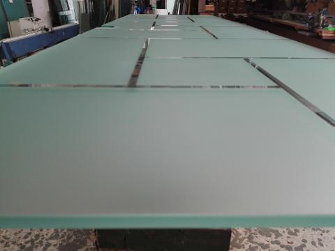 Anta di porta in vetro temperato 8mm trasparente decori rettangolari, disposti in varie angolazioni, lavorati in sabbiatura, lasciando uno spazio fra le figure geomentriche di 1cm in trasparenza. In seguito è stato applicato su tutta la superficie un prodotto acidante per rendere satinata la parte in sabbiatura.