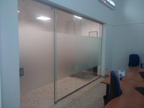 Parete fissa, composta da due ante, e porta scorrevole in vetro stratificato 10mm trasparente con lavorazione di sabbiatura nella fascia centrale
