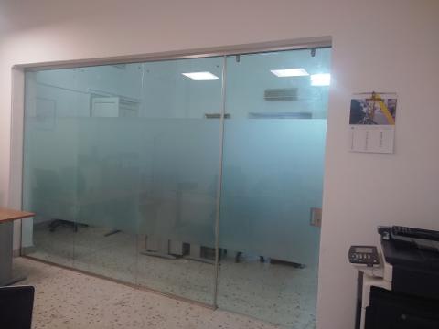 Parete fissa, composta da due ante, e porta scorrevole in vetro stratificato 10mm trasparente con lavorazione di sabbiatura nella fascia centrale. Montaggio a soffitto.