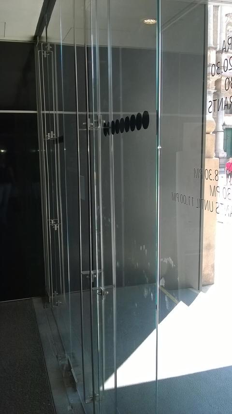 Maniglie in plexglass istallate su una porta in vetro temperato.
