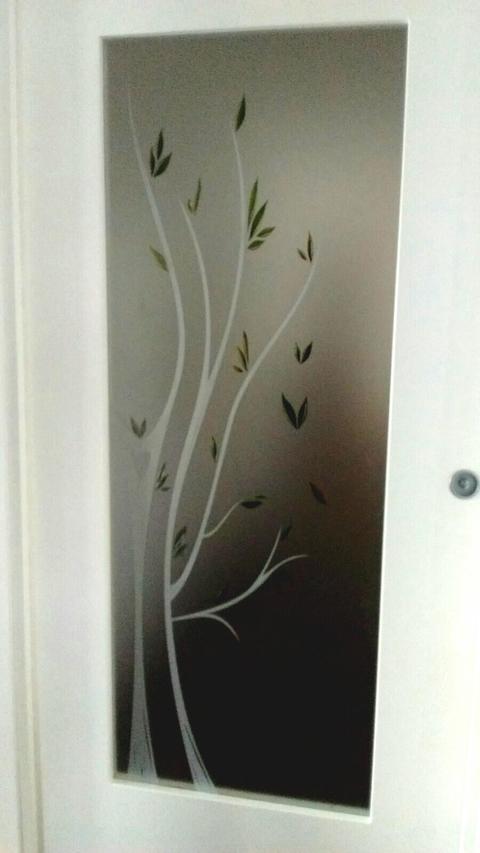 Vetro satinato su cui è stata effettuata una lavorazione di sabbiatura, in riferimento all' albero, arricchito dalle foglie che, invece, sono state abbellite dalle diverse sfumature di colore tipiche del periodo autunnale.