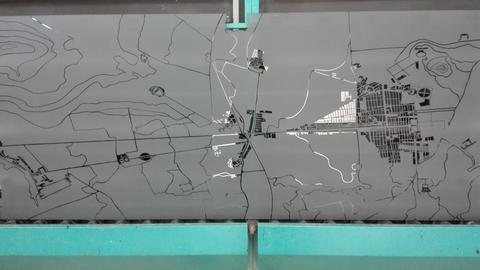 Porta in vetro temperato fumè su cui è stata rappresentata la pianta urbana della cittadina di Bagheria risalente agli inizi del '900. Il motivo è stato lasciato in trasparenza in contrasto alla sabbiatura dello sfondo.