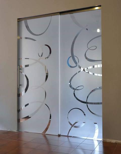 Porta con vetro satinato abbellito da decori circolari lasciati in trasparenza.