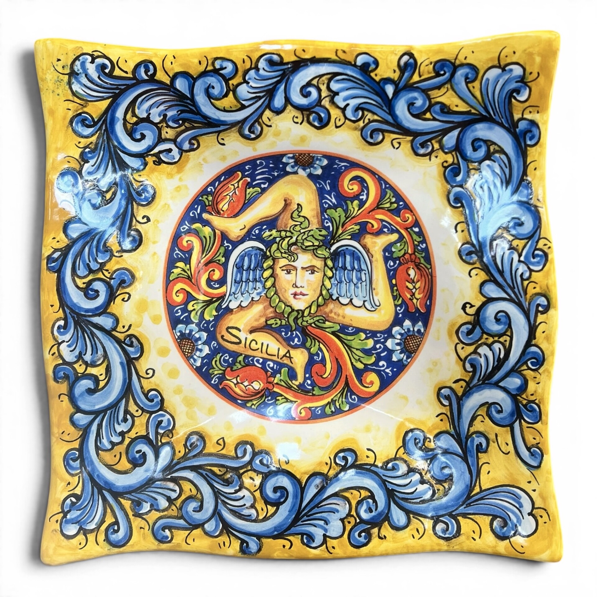 Piatto quadrato da parete decoro trinacria ornato blu fondo giallo in ceramica siciliana Produzione artigianale di Santo Stefano di Camastra varie misure