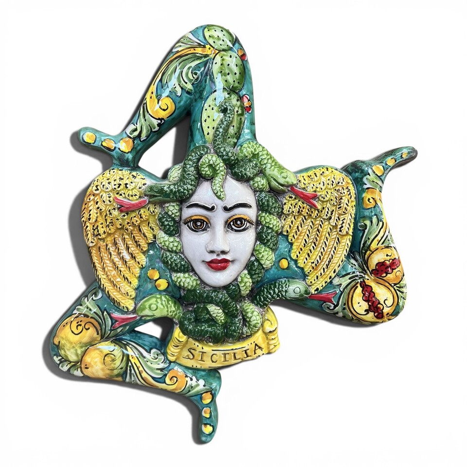 Trinacria ornamentale da parete decoro ornato frutta fondo verde in ceramica siciliana Produzione artigianale di Caltagirone lunghezza 36cm