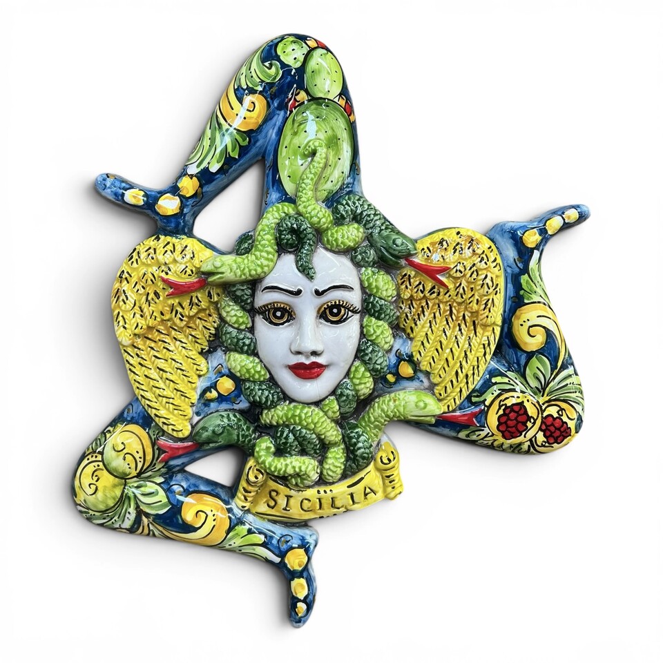 Trinacria ornamentale da parete decoro frutta su fondo blu in ceramica siciliana Produzione artigianale di Caltagirone lunghezza 36cm