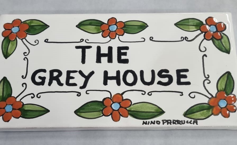 Piastrella personalizzata fiori arancio fondo bianco Nino Parrucca in ceramica