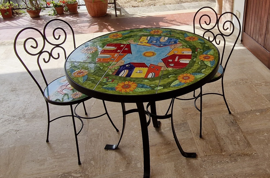 Tavolo d.cm.90 con/senza sedie in ferro e ceramica decoro Casette con Girasoli Nino Parrucca