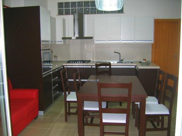 Cucina Completa di tavolo e scaffali.