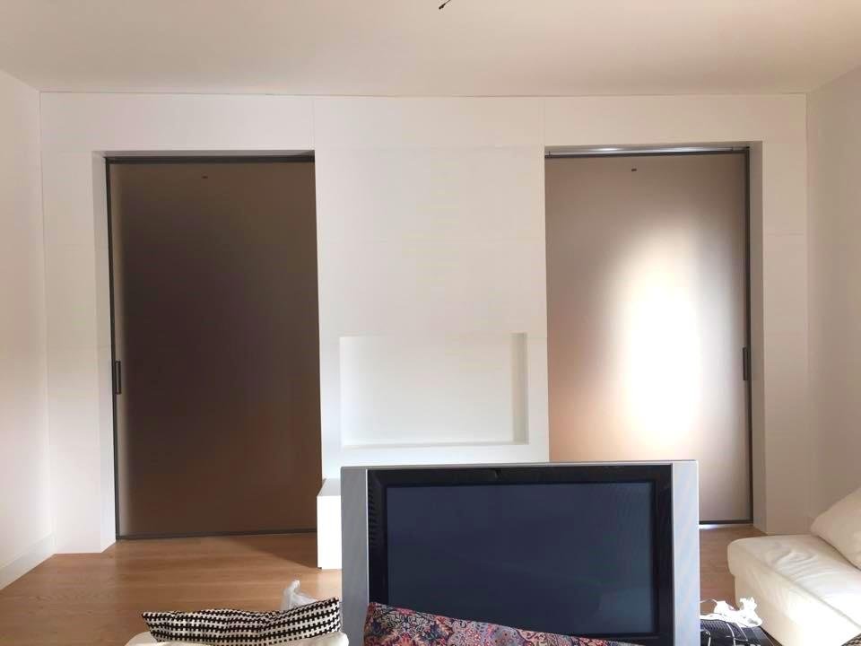 Parete in legno laccata con porte scorrevoli
