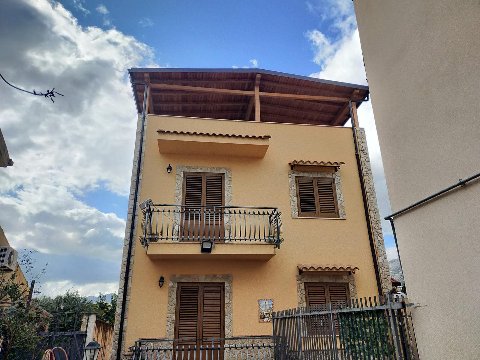 Tettoia in travi lamellari di abete impregnate color noce chiaro con tegole Onduvilla