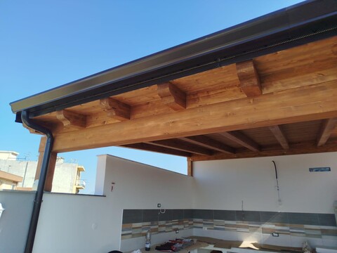 Tettoia in legno lamellare di abete impregnata color noce chiaro